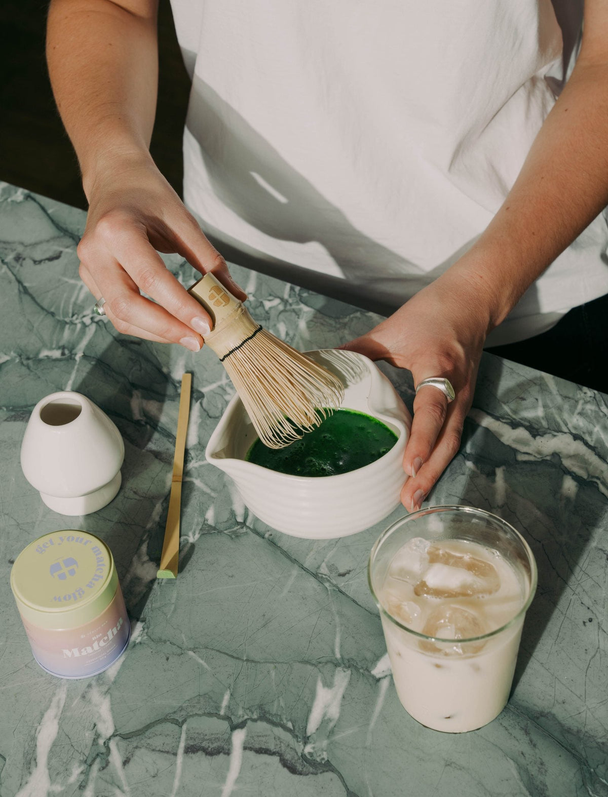 Bio Matcha wird in einer weißen Schale mit dem Chasen aufgeschlagen, daneben die Health Bar Ceremonial Dose