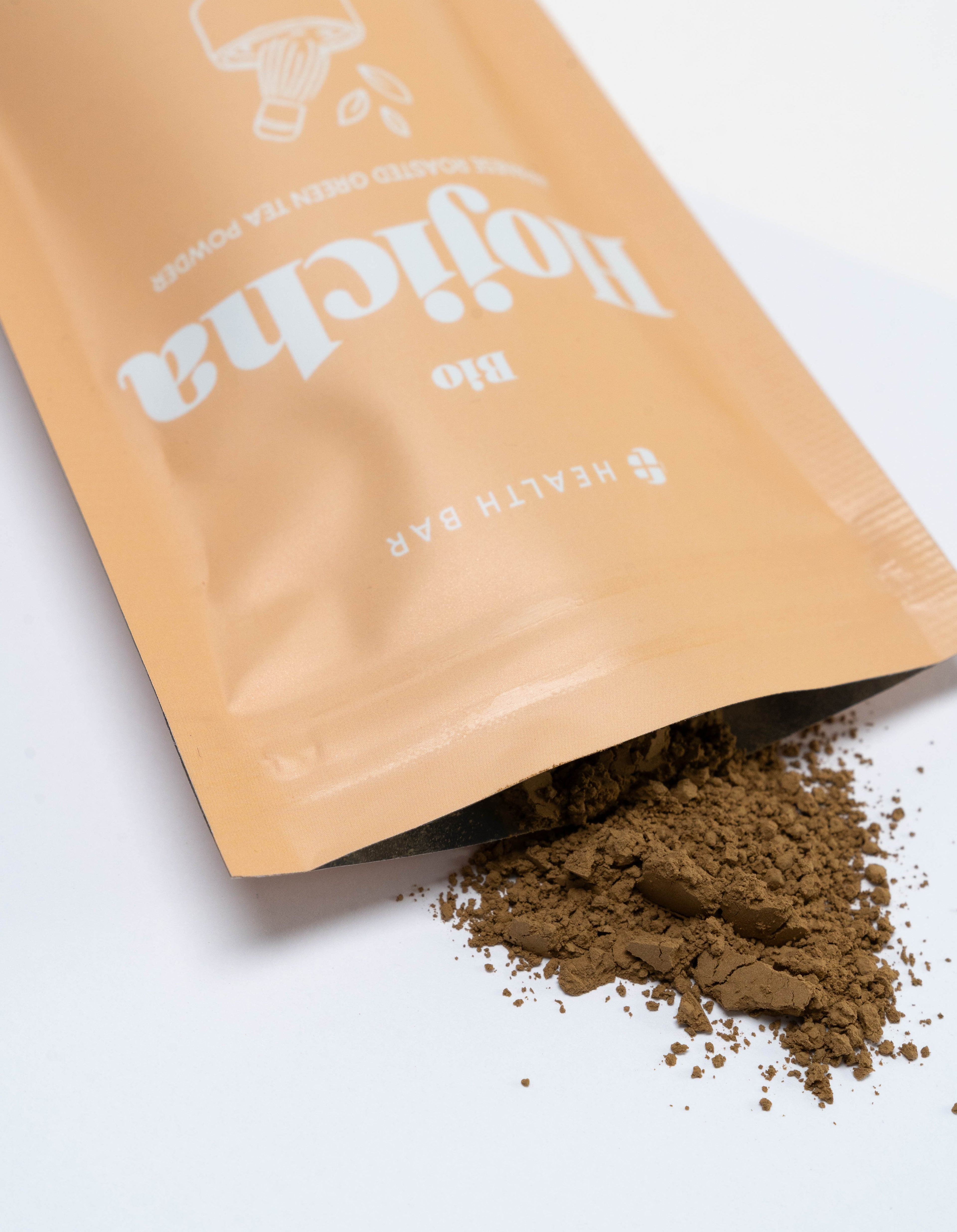 Health Bar Bio Hojicha Pulver aus geöffneter Verpackung feines geröstetes Grüntee Pulver auf weißem Hintergrund
