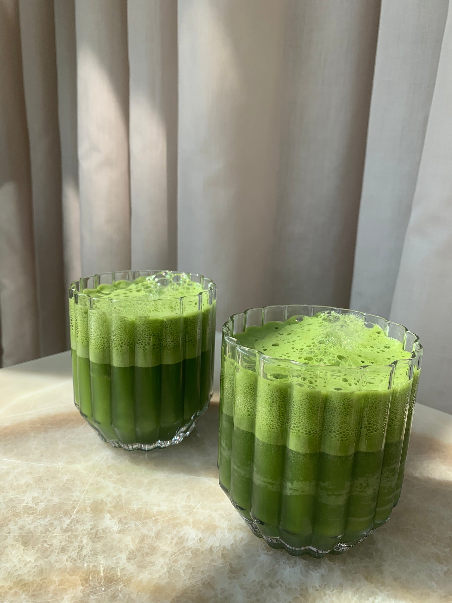 zwei gläser mit grünem matcha drink