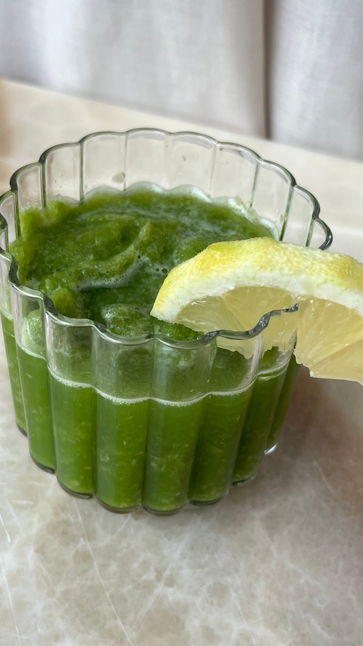 Frozen Grape Matcha Drink von Health Bar.eisgekühlter Matcha mit Trauben und Zitrone als Dekoelement am Glas