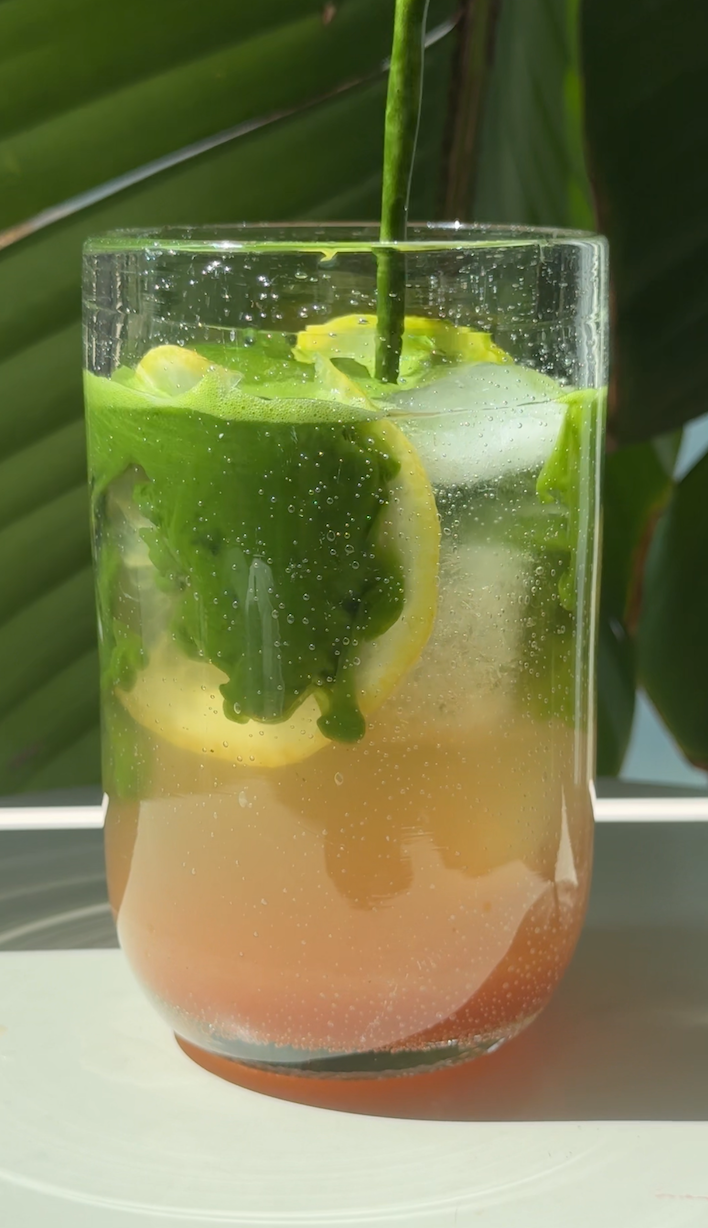 Erfrischender Peach Iced Tea Matcha mit Pfirsichsirup, Sencha, Eiswürfeln und cremig aufgeschlagenem Matcha im Glas.