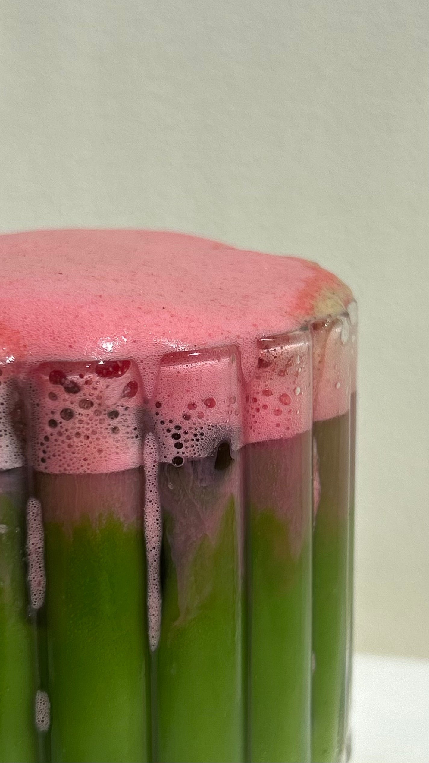 Strawberry Cloud Matcha Latte im Glas mit grünem Matcha und rosa Erdbeer Schaum obenauf