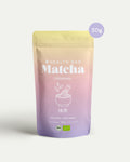 Bio Matcha Pulver 50 g Ceremonial von Health Bar im wiederverschliessbaren, luftdichten Beutel mit pastellfarbenem Verlauf in Rosa, Gelb und Lila sowie 50g Hinweis, freigestellt vor hellem Hintergrund