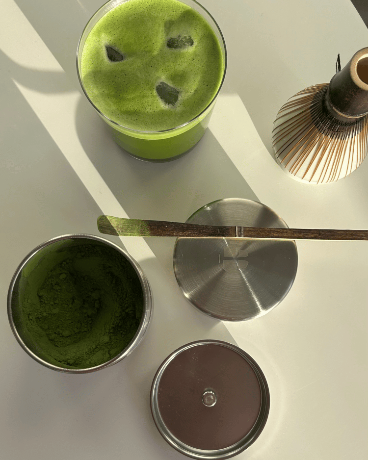 Natsume Edelstahl Dose mit Matcha Pulver und Zubehör auf grünem Untergrund – Tipps zur richtigen Matcha Lagerung