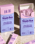Geöffnete Box Bio Ceremonial Matcha Sticks von Health Bar, daneben ein offener Stick mit Matcha Pulver