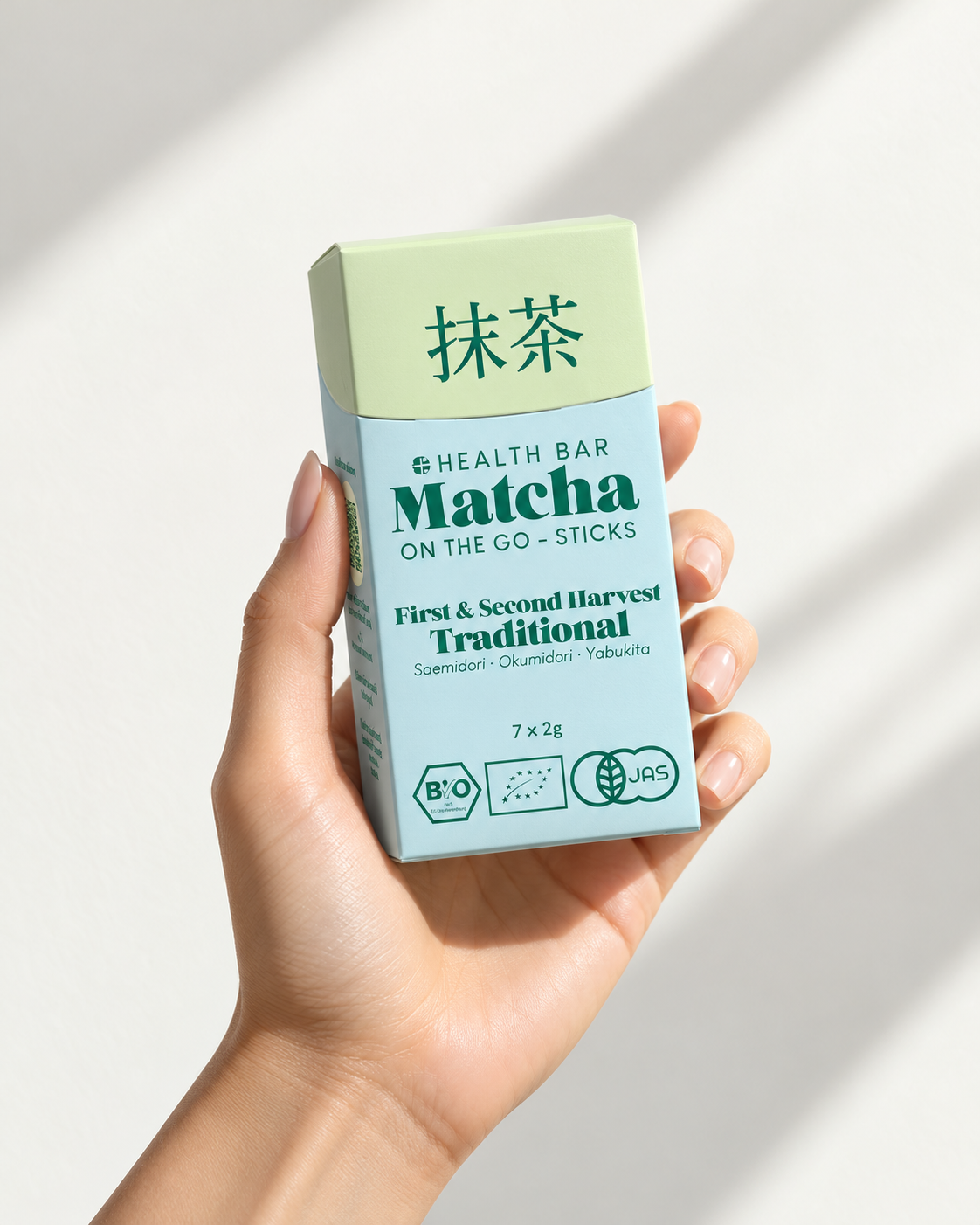 Box Bio Traditional Matcha Sticks von Health Bar in der Hand, 7 × 2 g, erste und zweite Ernte