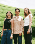 Nancy und Stefanie mit dem Farmer auf der Teefarm in Uji, Japan – leuchtend grüne Teefelder im Hintergrund
