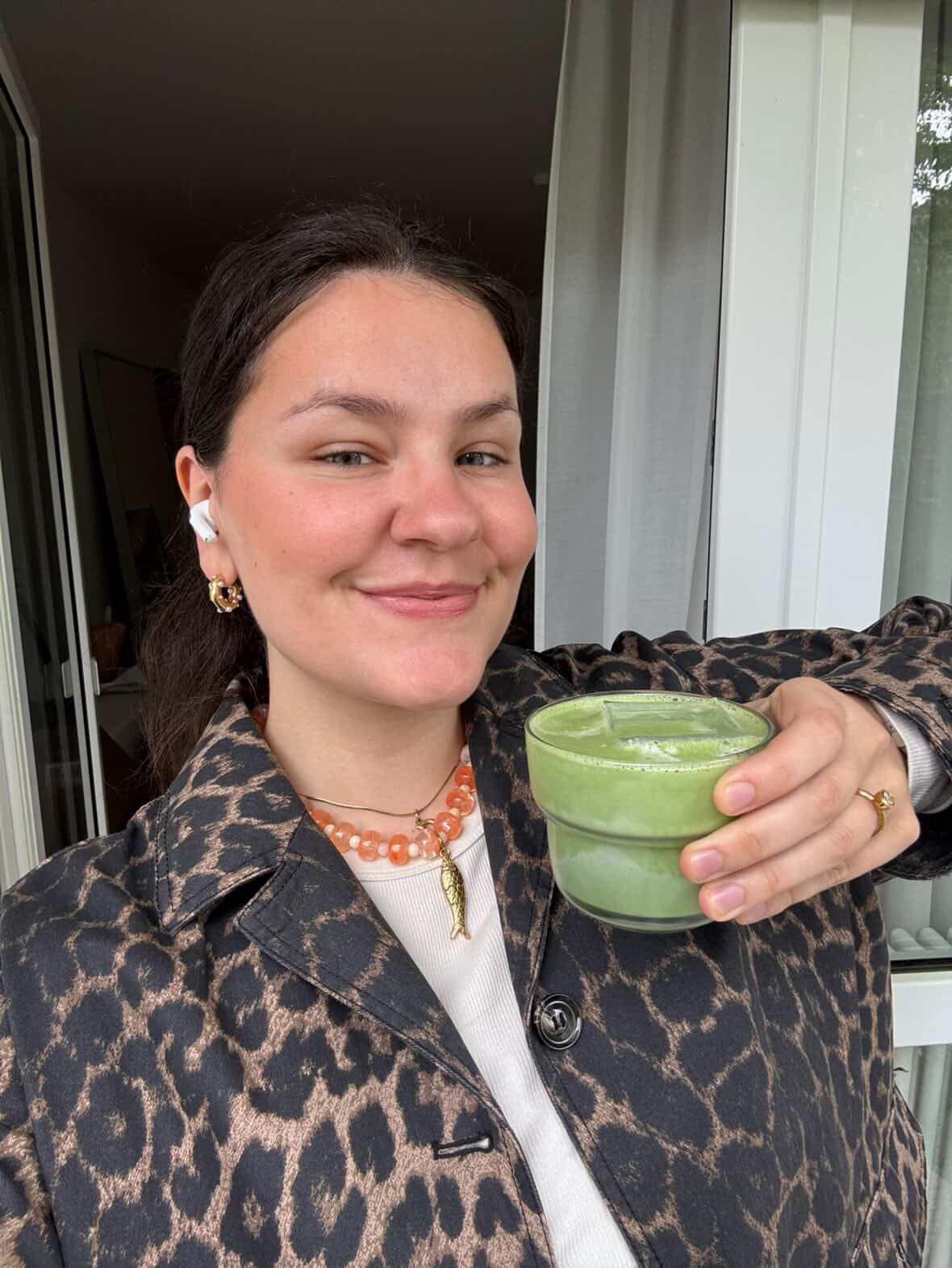Kundin hält einen Matcha Latte im Glas